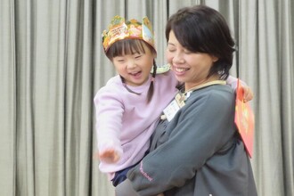 写真：園長先生に抱っこしてもらう年中児