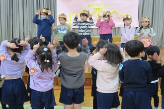 写真：歌のプレゼントをしてもらっている誕生児