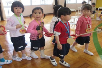 ペンダントをかけて退場する新入園児