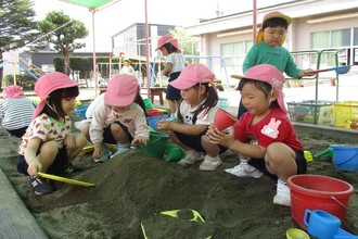 もも組の子どもたち砂場で楽しそうに遊んでいます