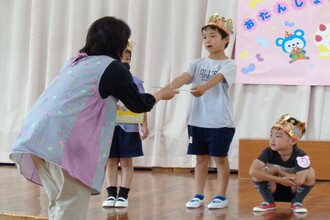 園長先生にプレゼントをもらう園児