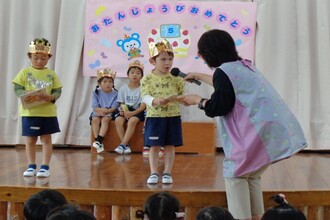 園長先生からプレゼントをもらう年中児