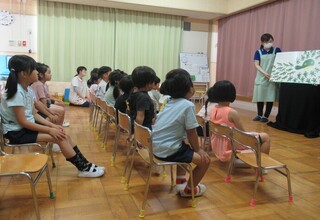 大型絵本「999ひきのきょうだい」を見ている子どもたち