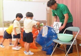 ごみの分別を一人ずつ体験しています。一つずつごみをもらって分別しています。
