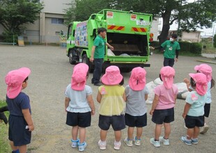 ごみ収集車を興味津々見ているこどもたち