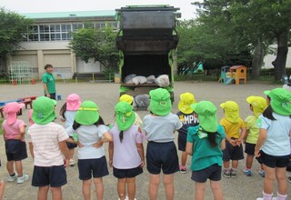 ごみ収集車の後ろが開くところを見ています