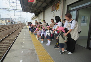 駅のホームで電車を待っている子どもたち