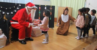 サンタさんにプレゼントをもらいながら顔をじっとみています