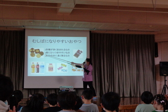 スライドを見て虫歯になりやすいおやつの説明を受ける年中児