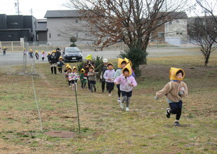 防災頭巾をかぶってリュックを背負って明野高校のみかん農園を走って避難