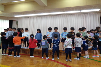 年中児より手作りの花を受け取る年長児