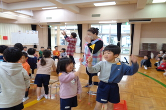 芯通しリレーで優勝し、一位の旗を持って喜ぶ年長児