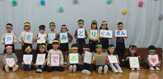 もも組、き組からみどり組にお祝いのメッセージボードを披露しています