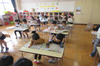 月刊誌をする園児