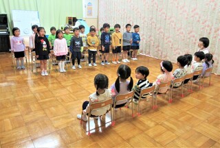 在園児と新入園児が向かい合って座っている