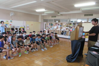 紙芝居を見る年長児