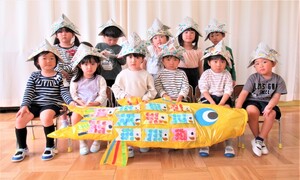4歳児が大きなこいのぼりと一緒に集合写真