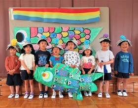 5歳児が大きなこいのぼりと一緒に集合写真