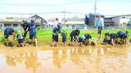 高校生と一緒に田んぼに入っているところ