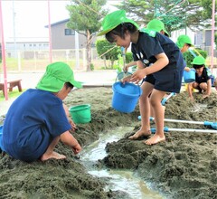 5歳児が砂場で水路を作っているところ