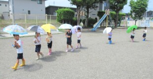 3歳児が傘をさして歩いているところ