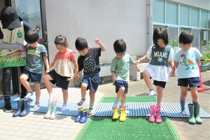 4歳児が立って長靴をはいているところ