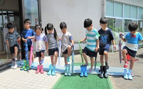 5歳児が立って長靴をはいているところ