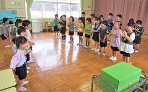 3歳児と4歳・5歳児が向き合って歌をうたっているところ