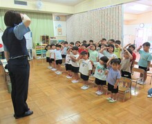子どもたちと警察官が敬礼をしているところ