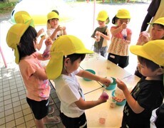 4歳児が草花で色水あそびをしているところ