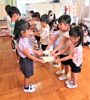 3歳児が5歳児に手紙を預けているところ