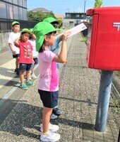 5歳児がポストに手紙を投函しているところ