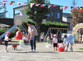 親子競技でだるまを神輿で運んでいるところ