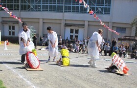 親子競技でそりに乗ったこどもを親が引っぱっているところ