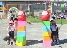 親子競技でだるまを神輿で運んでいるところ