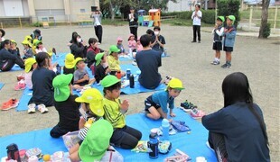 高校生と一緒に園庭でお弁当を食べるところ