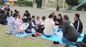 園庭で親子で豚汁を食べているところ