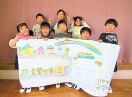 5歳児が描いた街の地図を持って全員写真