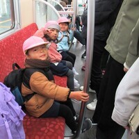 3歳児が電車のシートに座っているところ