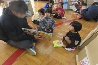 先生に読んでもらう園児