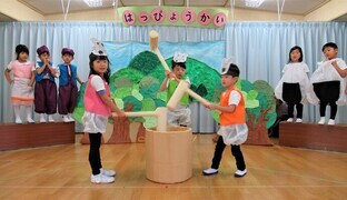4歳児が劇でおもちをついているところ