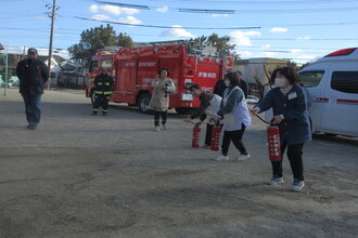 水消火器訓練をする教師