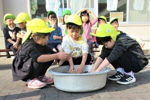 4歳児がさつまいもを洗っているところ