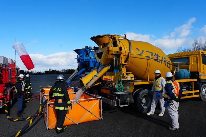 コンクリートミキサー車から水槽に補水している写真
