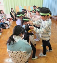 5歳児が3歳児にプレゼントを渡しているところ