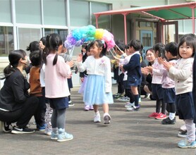 在園児の花道を卒園児が手を振って通っているところ