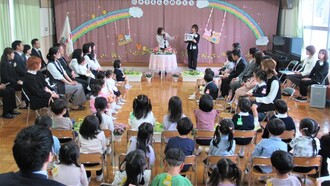 園長先生が子どもたちに幼稚園の遊びを紹介しているところ