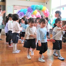 在園児のアーチをくぐって3歳児が入場しているところ