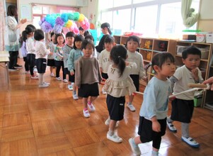 3歳児がアーチの下を1列で歩いているところ