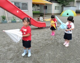3歳児が一人で傘を閉じようとしているところ